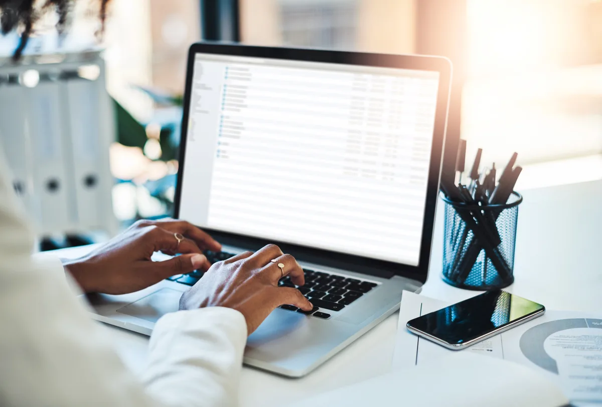 An email marketer reviewing a Klaviyo automation flow and revenue dashboard on a laptop at a desk
