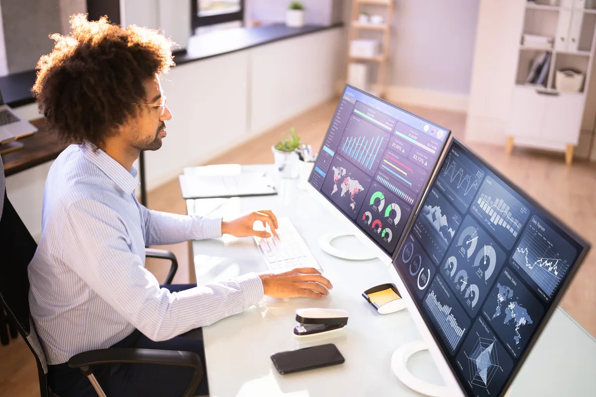 Marketing analyst reviewing conversion tracking and GA4 event data across two monitors at a desk