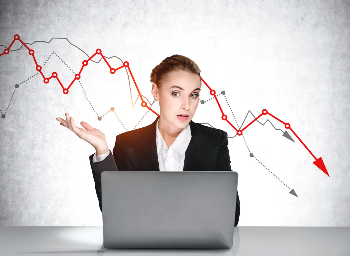 Marketer studying a declining conversion graph next to her laptop