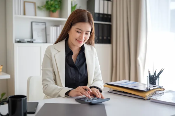 A CPA reviewing financial statements with a small-business owner across a desk in a modern firm office