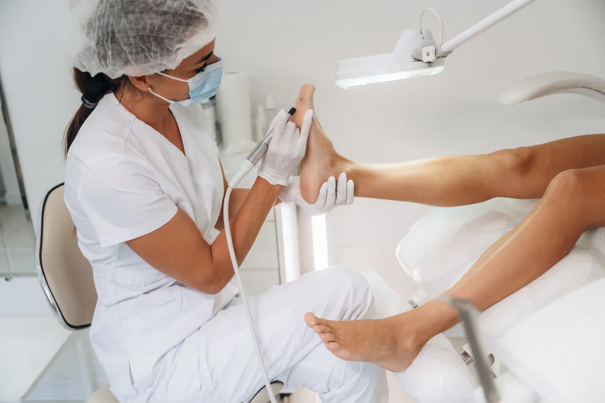 Podiatrist examining a patient's foot during an exam in a bright clinic room