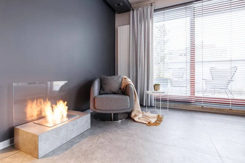 The quiet corner of the roastery café — an armchair with a knit throw beside a low fire