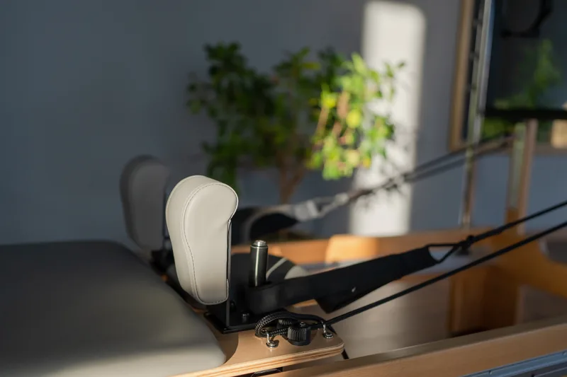 Reformer carriage and straps in soft window light before a morning class