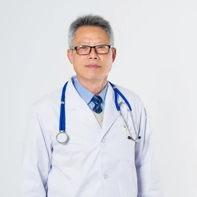 Dr. Kenneth Cho in a white coat and glasses with a blue stethoscope over his shoulders