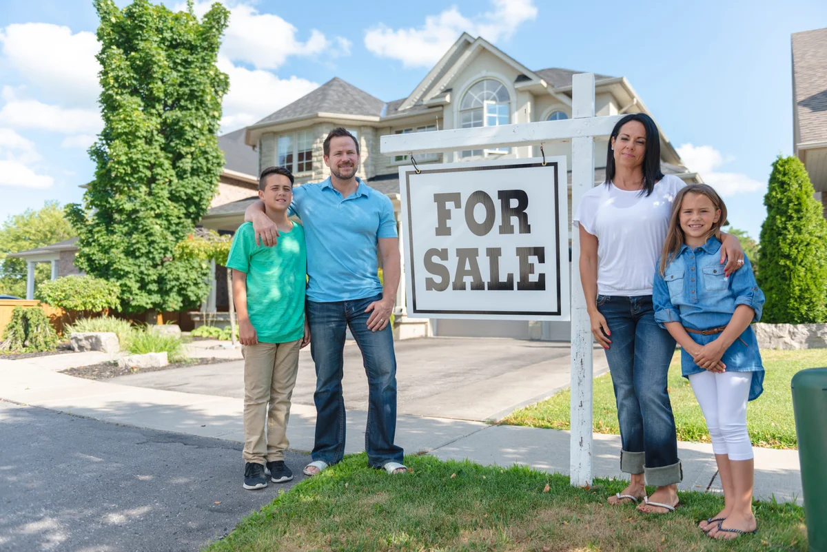 A mortgage broker walking a couple through renewal and refinance options at her office desk