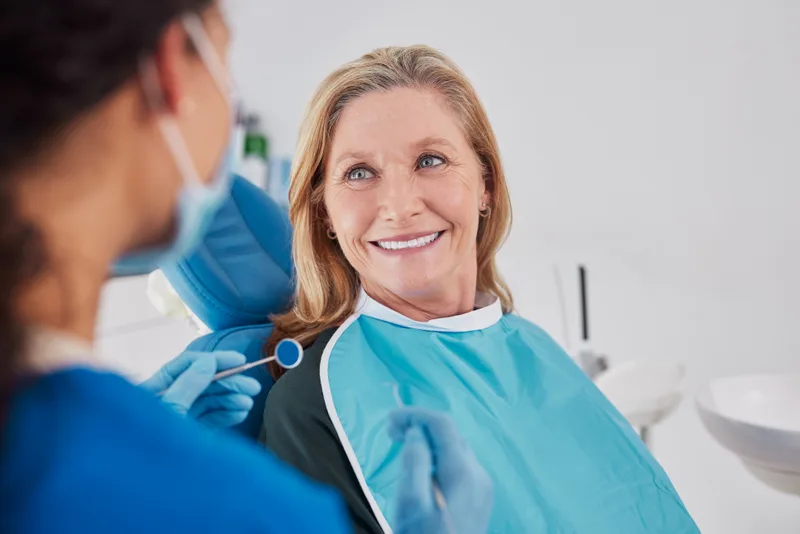 A relaxed patient looking up at her clinician during a gentle exam