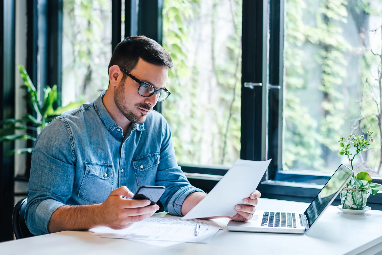 CPA walking a small-business owner through quarterly statements at her office desk