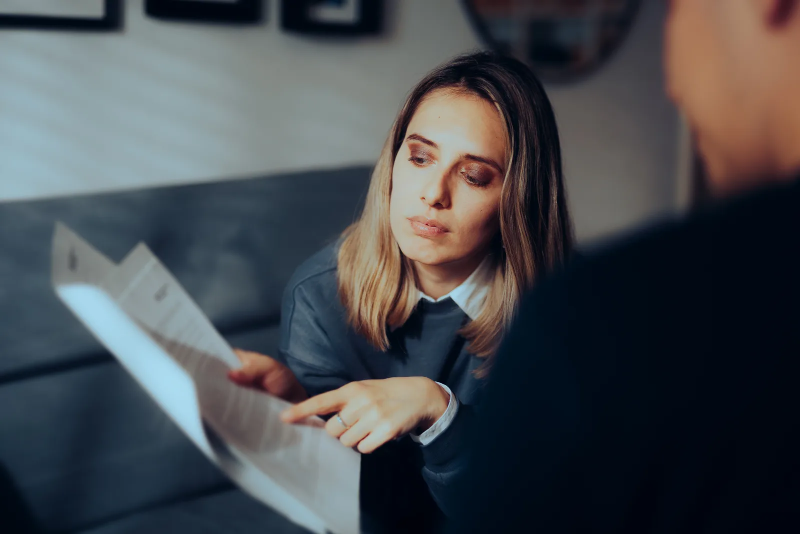 Bankruptcy attorney walking a worried couple through their debt paperwork at an office desk