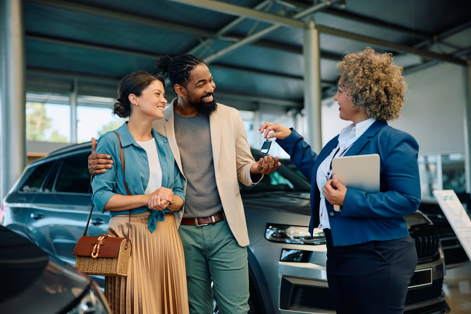 Salesperson congratulating a buyer taking delivery of their car on the dealership showroom floor