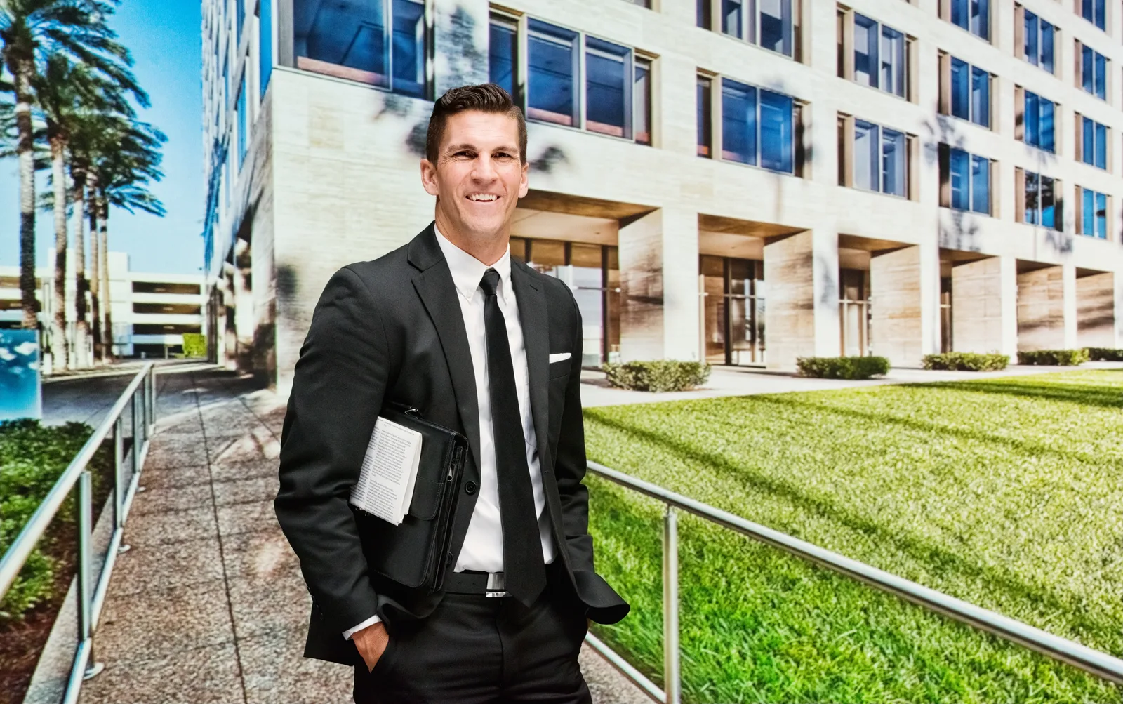 Commercial real estate broker carrying a property portfolio outside a mid-rise office building