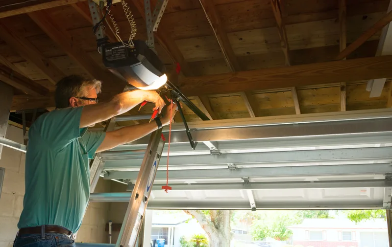 Technician repairing a residential garage door opener