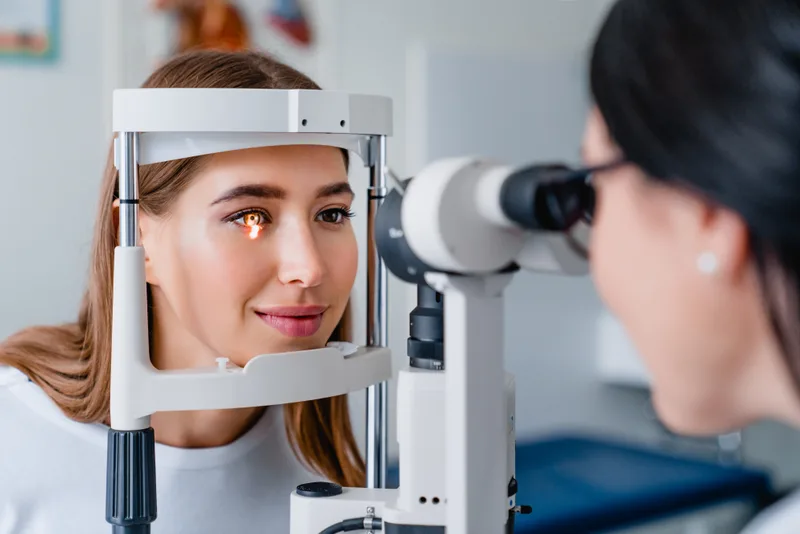 Optometrist examining a patient's eyes during an exam in a modern clinic