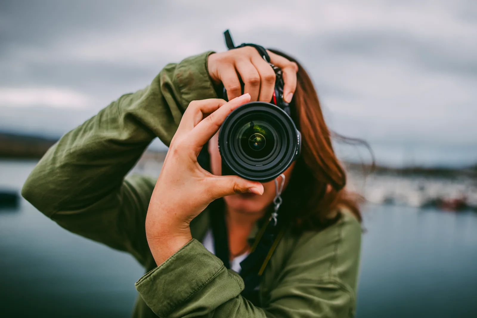 Wedding photographer framing a couple with a DSLR during an outdoor portrait session