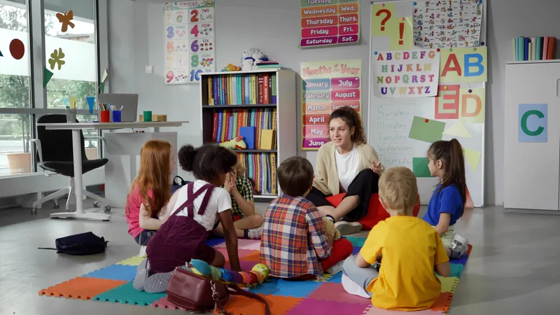 Preschool teacher reading with young children in a daycare classroom