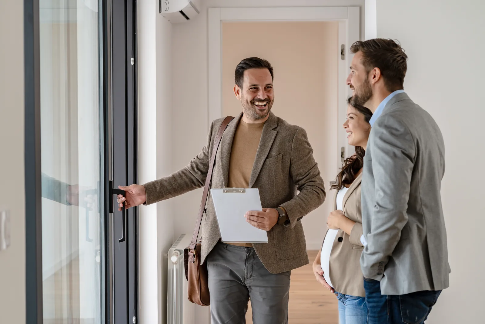 Property manager walking a couple through a vacant rental apartment during a showing