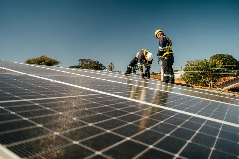 Workers installing solar panels on a residential roof