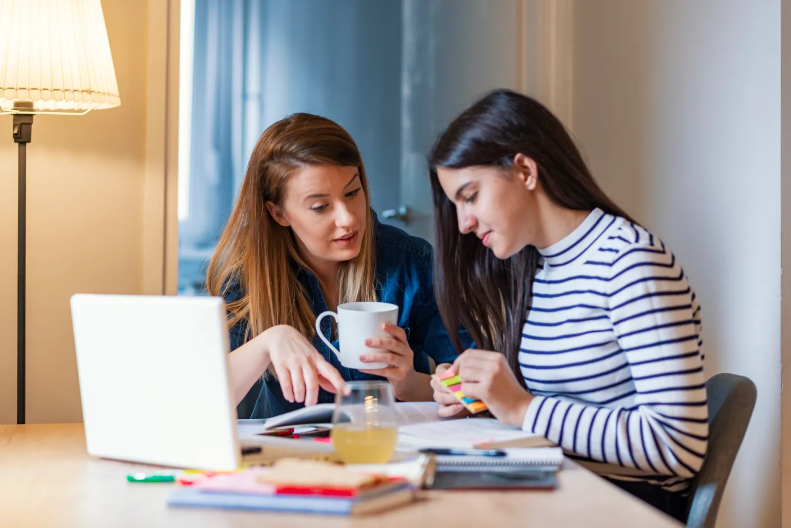 Tutor working one-on-one with a middle-school student on math problems at a learning-center table