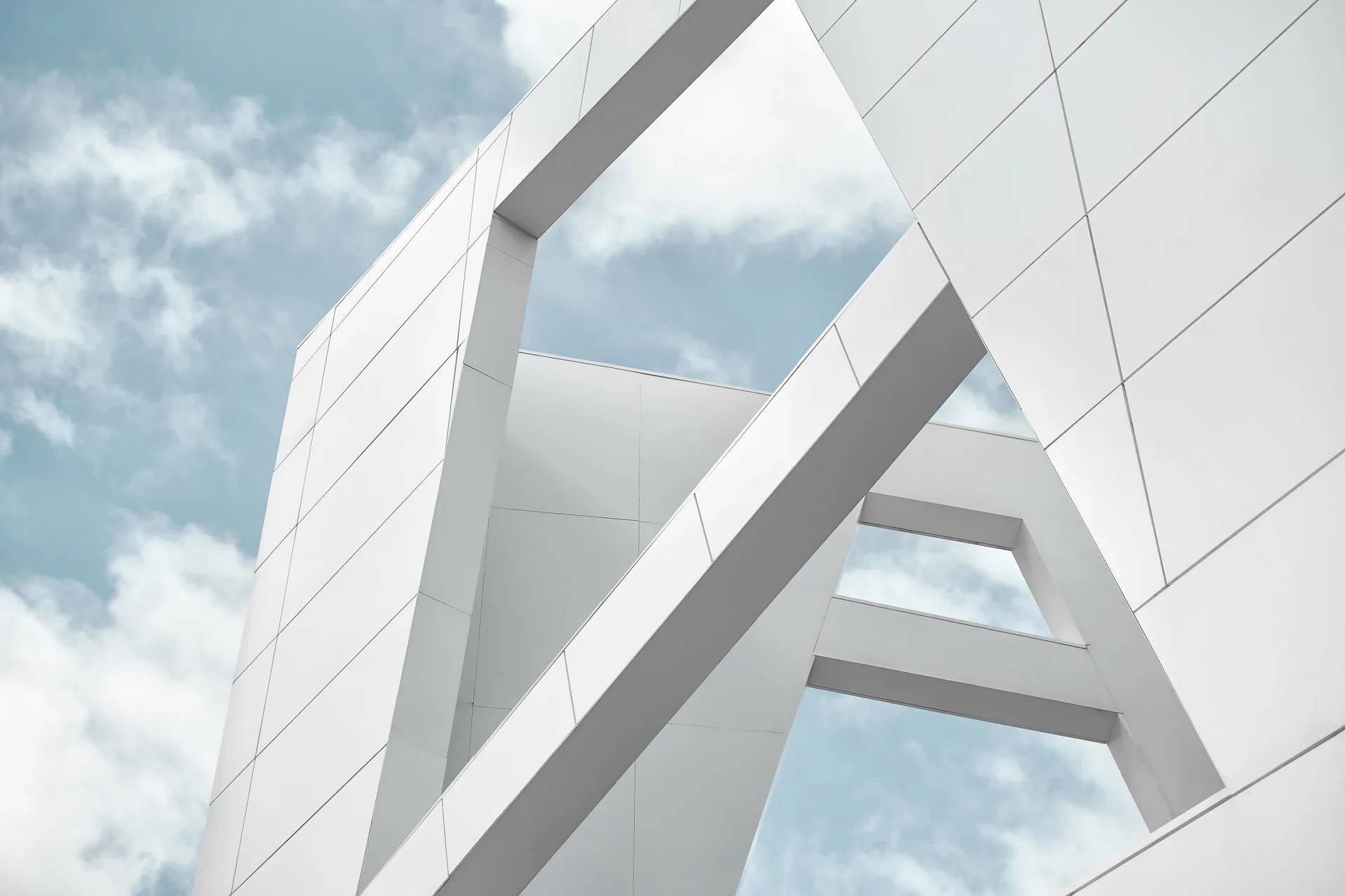 White architectural planes intersecting against a bright sky — geometry, light, and nothing wasted